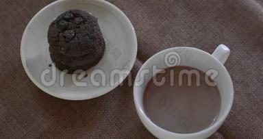 喝热巧克力在<strong>白色</strong>陶瓷杯与模糊的黑巧克力饼干<strong>棕色桌布</strong>。 为每个人提供美味的饮料